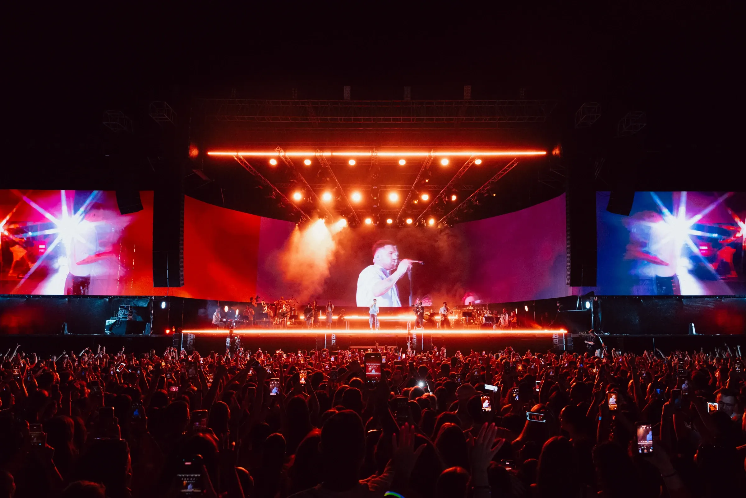 Wide view of the concert stage and audience under warm lighting