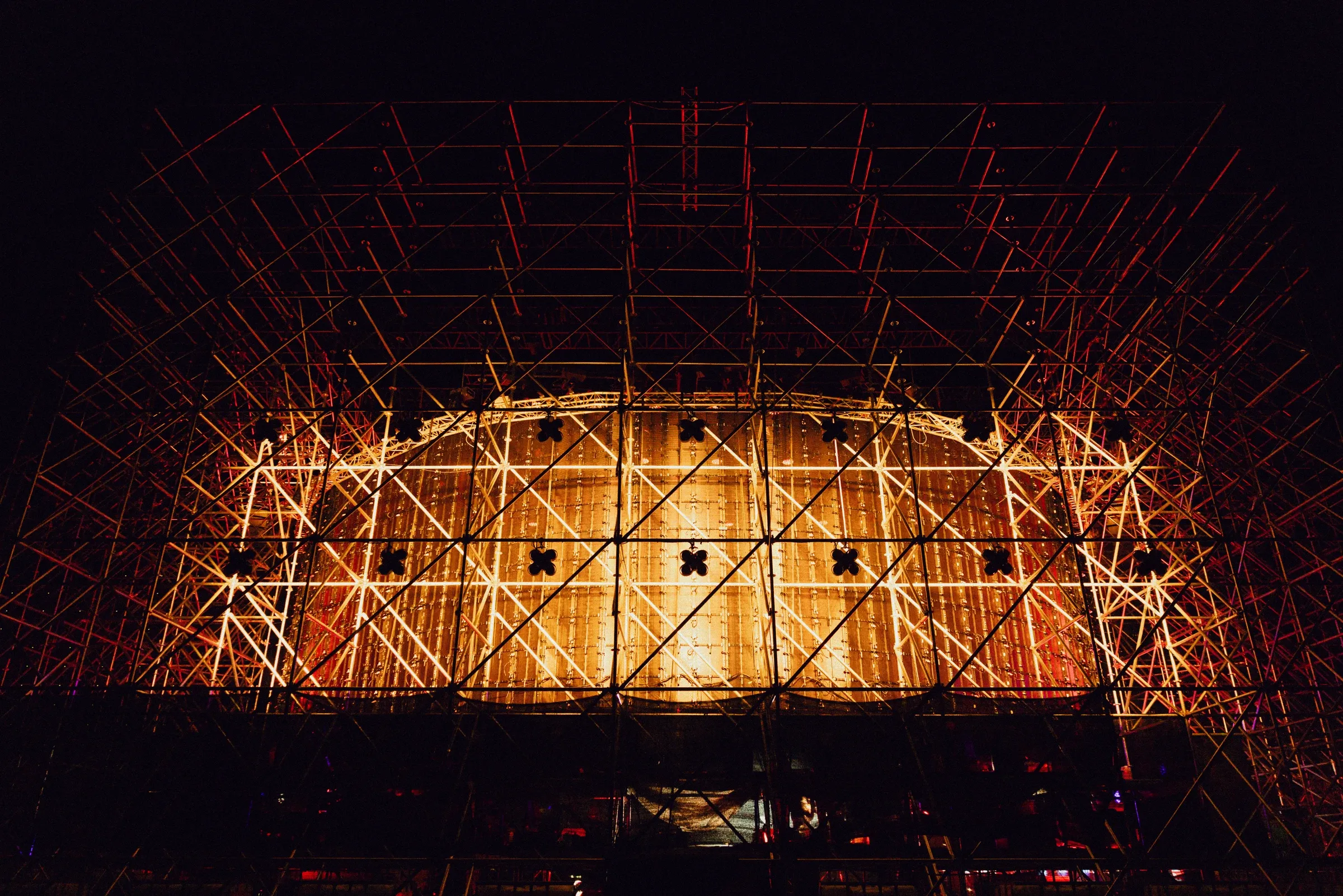 Stage structure and transparent LED mesh seen from behind at night